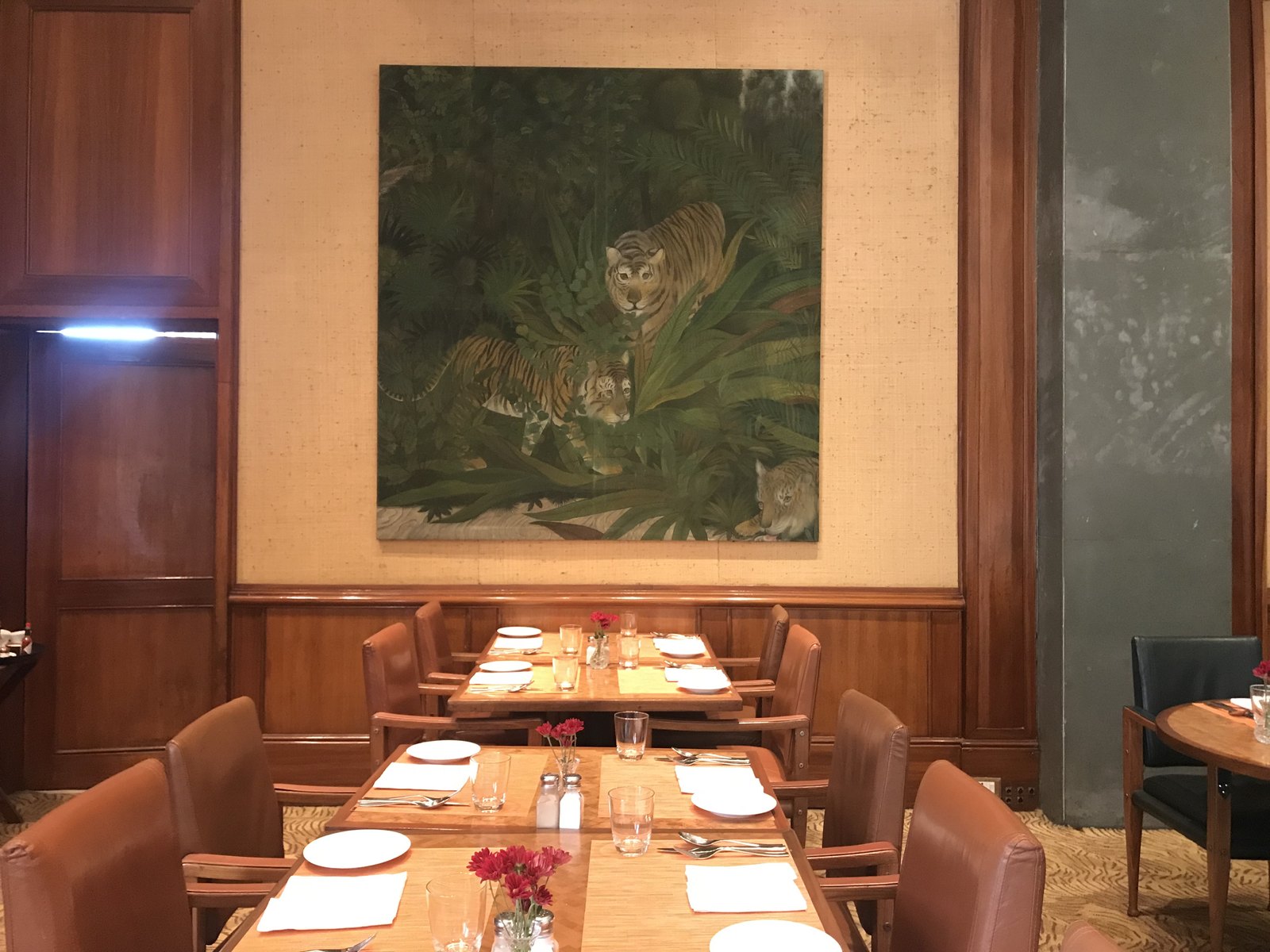 A tiger painted into the foliage — the wildlife wall in the Machan dining room