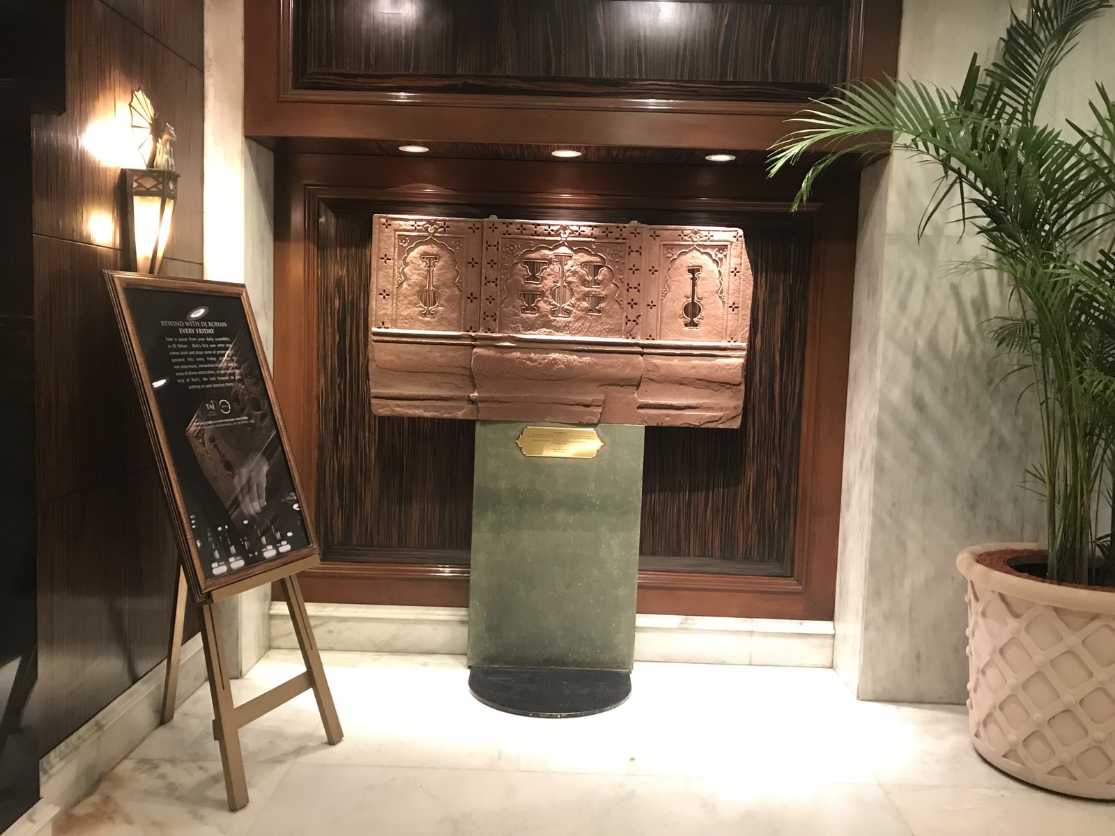 A copper artwork raised in relief on a verdigris plinth